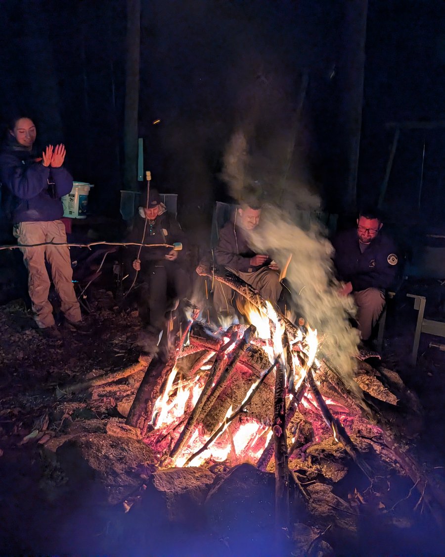 Team gathered around the fire after a night training session